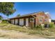 Exterior of a three-car garage with white doors, set on a gravel driveway with grassy surroundings and barrel containers at 11475 Us Highway 85, Littleton, CO 80125