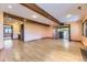 Open living room with hardwood floors, exposed beams, and access to other rooms at 11475 Us Highway 85, Littleton, CO 80125
