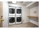 Laundry room with two stacked sets of new, white washers and dryers at 444 17Th St # 802, Denver, CO 80202