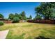 Spacious backyard features a large grassy area surrounded by a tall wooden fence and mature trees at 5945 W Colgate Pl, Denver, CO 80227