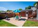 Backyard patio features a dining set with umbrella, a grill, and access to a brick building with wooden stairs at 5945 W Colgate Pl, Denver, CO 80227