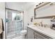 Bathroom with a glass walk-in shower with light gray vanity, backsplash and flooring at 5945 W Colgate Pl, Denver, CO 80227