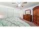 Bedroom with ceiling fan, wood dresser and wardrobe and a comfy green bed spread at 5945 W Colgate Pl, Denver, CO 80227