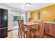 Dining room boasts wood floors, yellow accent wall, and adjacent access to screened in porch at 5945 W Colgate Pl, Denver, CO 80227