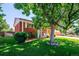 Traditional brick home with a lush front lawn and a large shade tree, offering curb appeal and a welcoming ambiance at 5945 W Colgate Pl, Denver, CO 80227