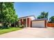 Red brick home with a spacious driveway leading to a two-car garage, complemented by green landscaping at 5945 W Colgate Pl, Denver, CO 80227