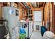 Utility room with exposed wood, water heater, washer, dryer, and storage shelves at 5945 W Colgate Pl, Denver, CO 80227