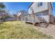 The back of the home featuring a small deck with outdoor furniture, and well maintained lawn at 9851 Castle Ridge Cir, Highlands Ranch, CO 80129