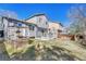 The back of the home featuring a small deck with a BBQ, gardening box, and well maintained lawn at 9851 Castle Ridge Cir, Highlands Ranch, CO 80129