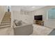 Basement lounge area with stairs, large couch, and TV at 9851 Castle Ridge Cir, Highlands Ranch, CO 80129