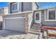 Close up of home featuring the front entry, address, two car garage and landscaped entrance at 9851 Castle Ridge Cir, Highlands Ranch, CO 80129