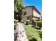 Exterior view showcasing the side of the home, green lawn, and mature trees providing shade and curb appeal at 1825 S Pitkin Cir # 10, Aurora, CO 80017