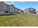 Wide backyard with green lawn, fence and view of neighborhood homes at 5723 Berry Ridge Way, Castle Rock, CO 80104