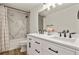 Bathroom featuring double vanity, modern fixtures, large mirror, and decorative marble tile in shower at 5723 Berry Ridge Way, Castle Rock, CO 80104