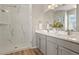 Elegant bathroom with a double vanity, modern fixtures, and a glass-enclosed shower with marbled tile at 5723 Berry Ridge Way, Castle Rock, CO 80104