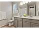 Bright bathroom featuring double sinks, modern fixtures, and light gray cabinets at 5723 Berry Ridge Way, Castle Rock, CO 80104