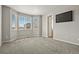 Bright bedroom featuring a large window with neighborhood views, neutral carpeting, and a wall-mounted television at 5723 Berry Ridge Way, Castle Rock, CO 80104