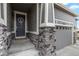 The main entrance of the house with a welcoming door and beautiful stone accents at 5723 Berry Ridge Way, Castle Rock, CO 80104