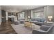 Bright, open-concept living room with hardwood floors, modern furnishings, and large windows at 5723 Berry Ridge Way, Castle Rock, CO 80104