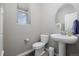 Modern powder room with a pedestal sink, round mirror, and natural light at 918 Honey Berry Ct, Elizabeth, CO 80107