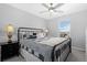 Bedroom with large bed, ceiling fan, and a black nightstand with a lamp at 918 Honey Berry Ct, Elizabeth, CO 80107