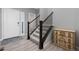 Inviting entryway features stairs with modern dark wooden railings and light hardwood flooring at 918 Honey Berry Ct, Elizabeth, CO 80107