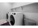 Modern laundry room featuring a new washer, dryer and shelving for storage at 918 Honey Berry Ct, Elizabeth, CO 80107