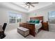 Bright main bedroom features a ceiling fan, a large window, and wood furniture at 918 Honey Berry Ct, Elizabeth, CO 80107