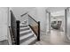Light grey carpeted staircase with dark wood railing and light hardwood floors at 918 Honey Berry Ct, Elizabeth, CO 80107