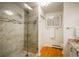 Modern bathroom featuring tiled walk-in shower with glass door, granite countertop, and storage at 4192 Timbervale Dr, Evergreen, CO 80439