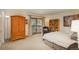Cozy bedroom with natural light from private balcony, hardwood armoire, and decorative bookshelf at 4192 Timbervale Dr, Evergreen, CO 80439