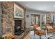 Charming stone fireplace creates a cozy atmosphere in the living area with seating and sliding door access to the deck at 4192 Timbervale Dr, Evergreen, CO 80439