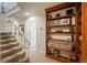 Inviting hallway with staircase and custom wood built-in shelving, providing ample storage at 4192 Timbervale Dr, Evergreen, CO 80439