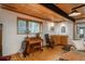 Cozy living area features a wood ceiling, a baby grand piano, and a wet bar for relaxation at 4192 Timbervale Dr, Evergreen, CO 80439
