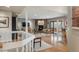 Bright, open-concept living room with hardwood floors, stone fireplace, and seamless access to the outdoor deck at 4192 Timbervale Dr, Evergreen, CO 80439