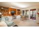 Open living room featuring custom built-ins, desk area, and access to an outdoor sunroom at 4192 Timbervale Dr, Evergreen, CO 80439
