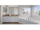 Bright bathroom featuring dual sinks, granite counters, a soaking tub, and a large window at 1808 Southard St, Erie, CO 80516