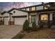 Inviting home with a covered porch, blue door, mature trees, and a two-car attached garage at 1808 Southard St, Erie, CO 80516