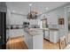 Bright kitchen with white cabinetry, a granite island, stainless appliances, and hardwood floors at 1808 Southard St, Erie, CO 80516