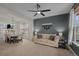 Open-concept living room featuring neutral colors, a ceiling fan, and seamless access to the dining area at 1808 Southard St, Erie, CO 80516