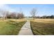 Winding paved pathway with expansive green space featuring a community tennis court and walking path at 1808 Southard St, Erie, CO 80516