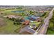 Aerial view of a brick building, parking lots, tennis courts, and green spaces in a thriving community at 1518 Sepia Ave, Longmont, CO 80501