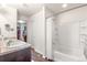 Modern primary bathroom with double vanity, bathtub with shower, and walk in closet at 1518 Sepia Ave, Longmont, CO 80501