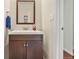 Modern half bathroom with dark cabinets, stylish mirror, and neutral colors at 1518 Sepia Ave, Longmont, CO 80501
