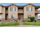Inviting townhome with covered balcony, stone accents, green grass, and a welcoming front entrance at 1518 Sepia Ave, Longmont, CO 80501