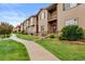 Charming townhome with wood siding, stone accents, small balconies, and landscaped front yard at 1518 Sepia Ave, Longmont, CO 80501