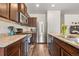 Modern kitchen with stainless steel appliances, dark wood cabinets, and stone countertops at 1518 Sepia Ave, Longmont, CO 80501