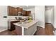 Beautiful kitchen with stainless appliances, kitchen island, dark wood cabinets, and hard wood floors at 1518 Sepia Ave, Longmont, CO 80501