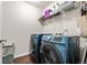 Modern laundry room featuring a front-load washer and dryer, complemented by overhead shelving and neutral walls at 1518 Sepia Ave, Longmont, CO 80501