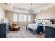 Elegant primary bedroom with tray ceiling, sitting area, and bright windows at 14537 Honolulu Cir, Parker, CO 80134
